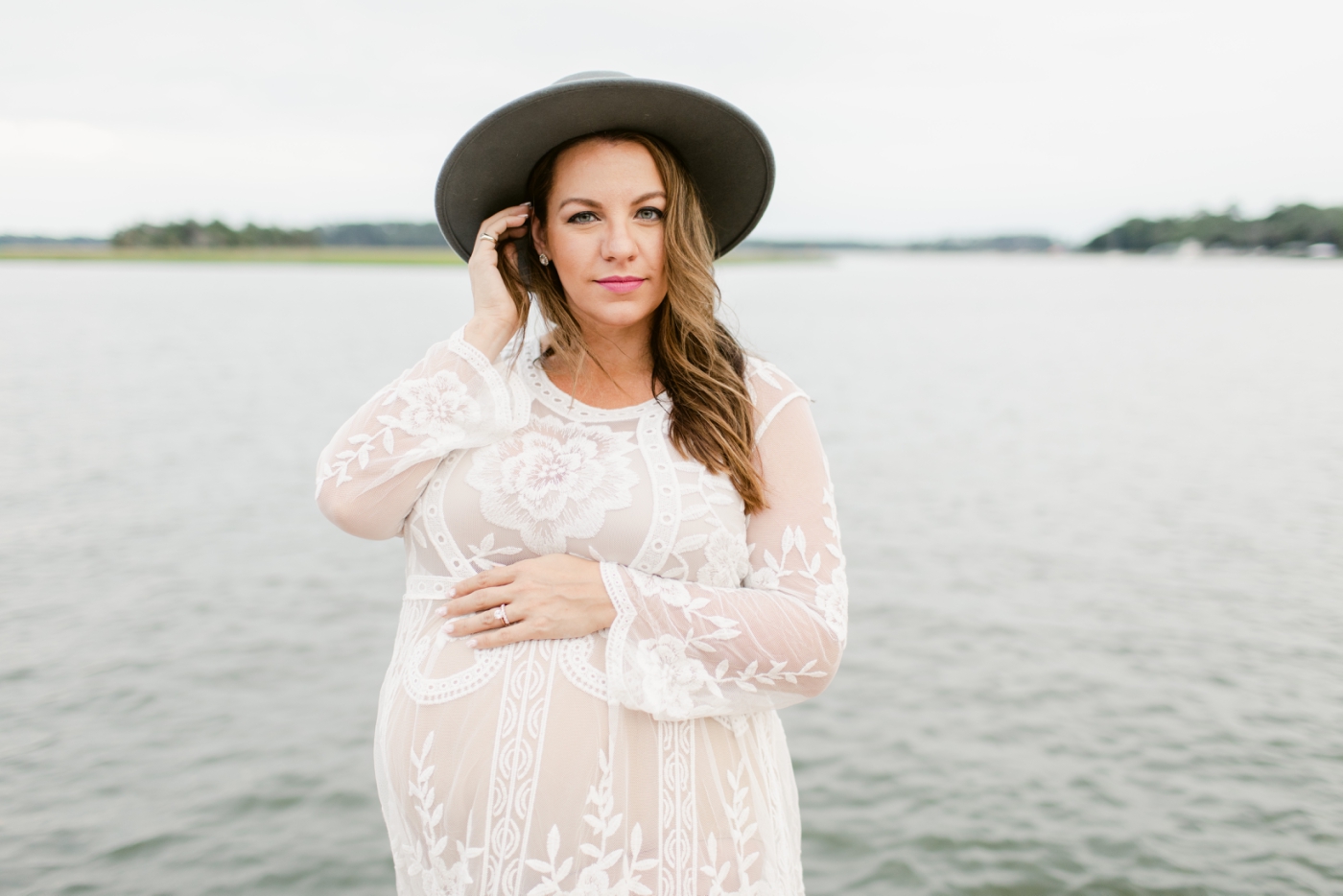 maternity session in white gown and gray hat
