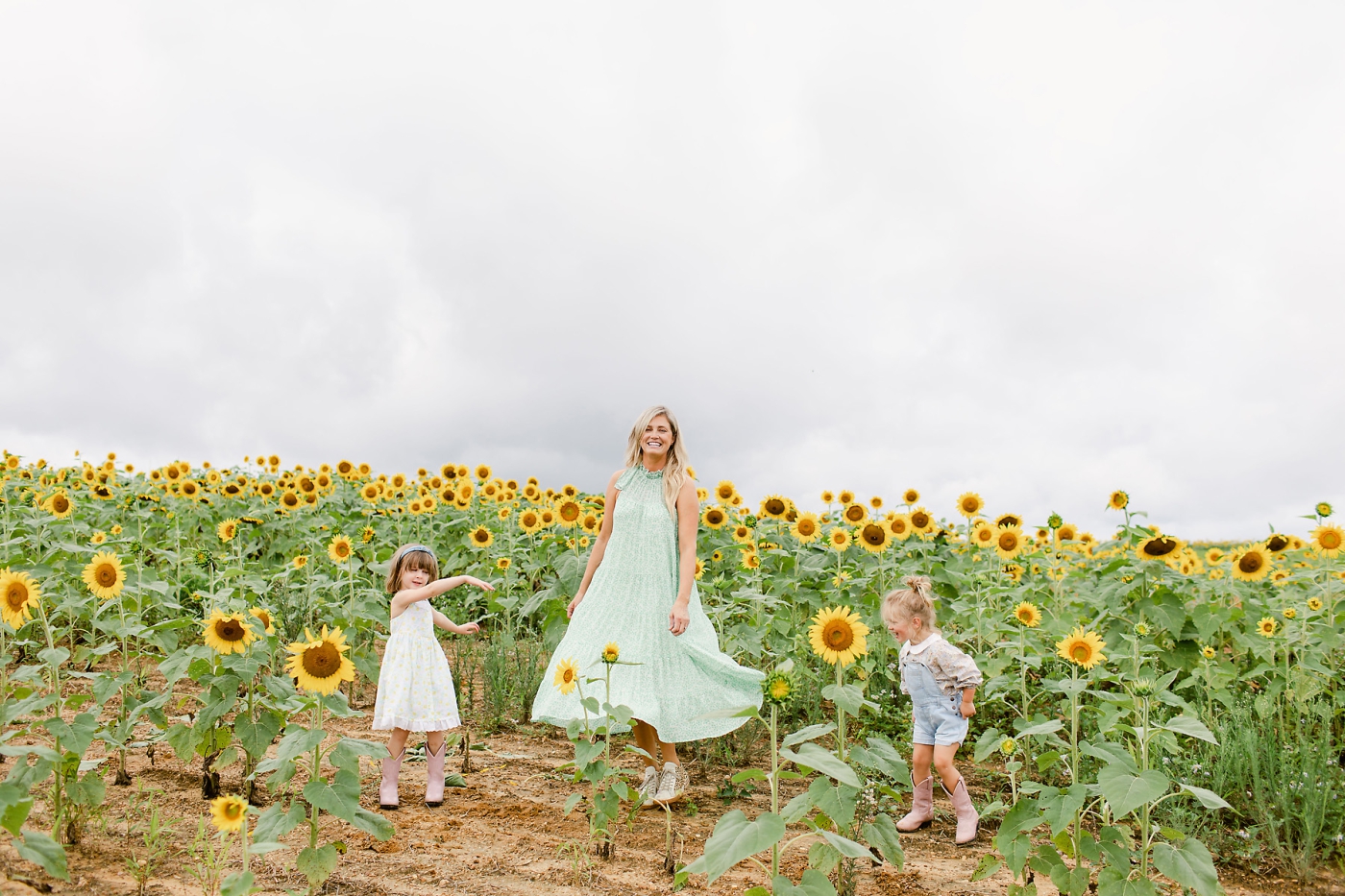 mother with her daughters in sunflower field