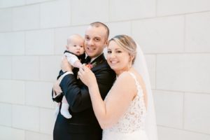 bride and groom with their baby