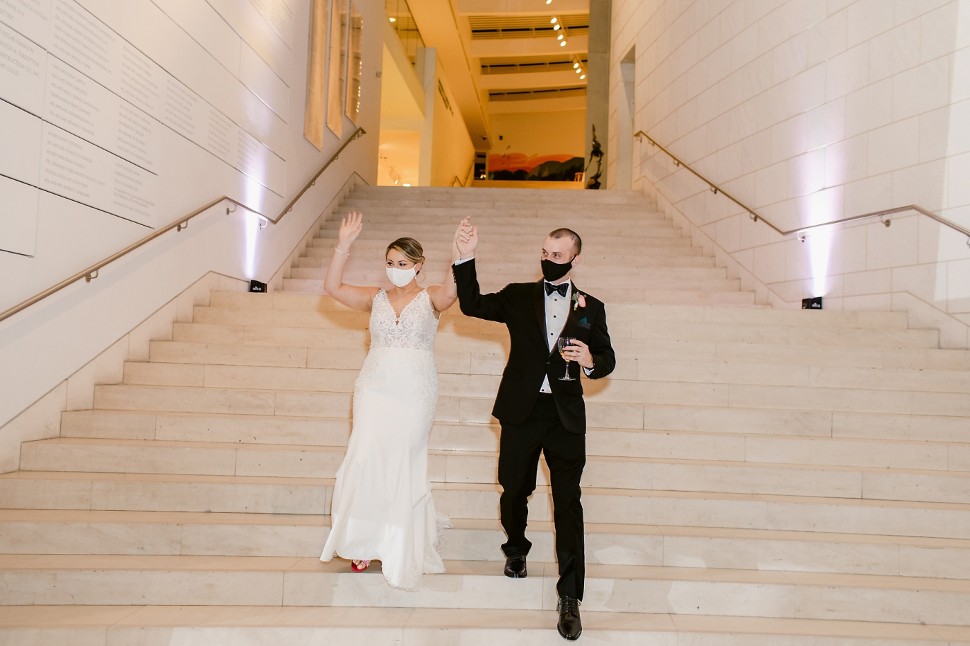 bride and groom entering reception with masks