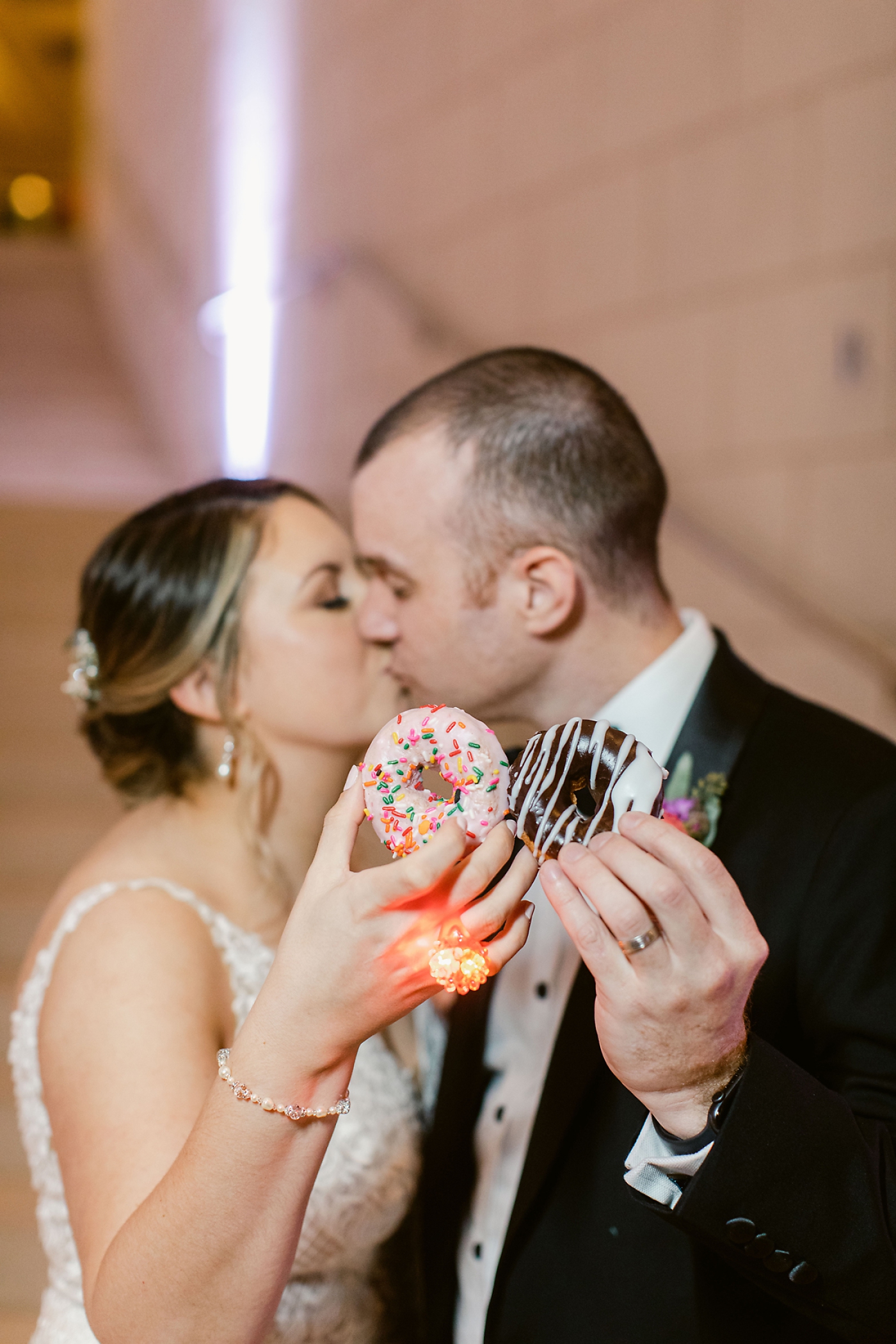 bride and groom holding donuts