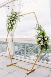 hexagon ceremony arch with white and greenery florals