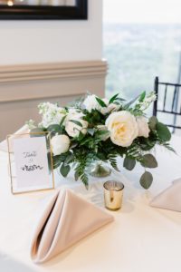 white roses and greenery centerpieces