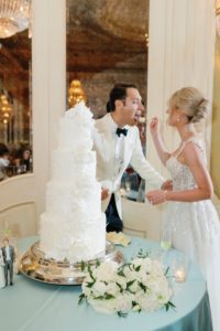 bride and groom cutting their white floral wedding cake