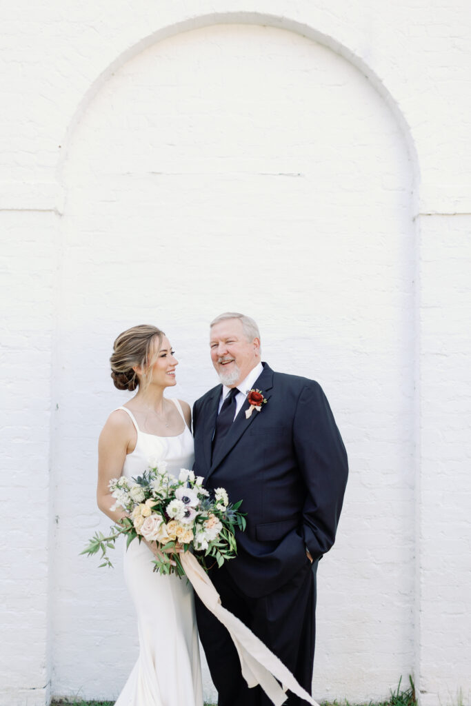 A bride and her father laughing.