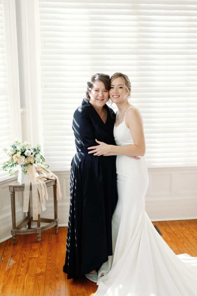 a mother and daughter smiling on her wedding day.