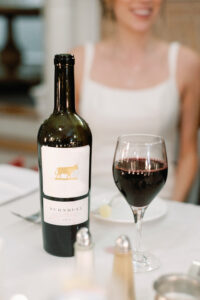 A bottle of wine with a half-full glass.