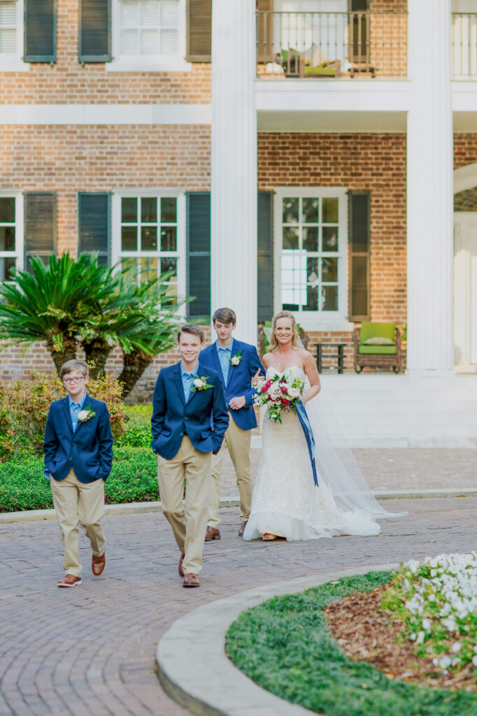 A bride walking with her sons down the aisle. 