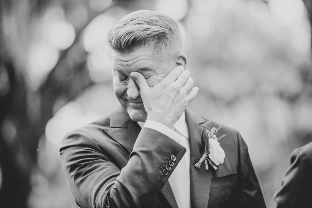 A groom tears up as he sees his bride walking down the aisle. 