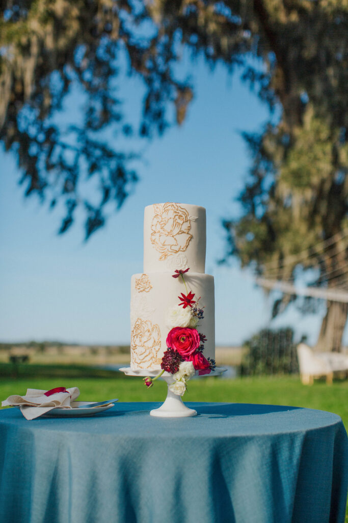 A white Wedding Cake with Red Flowers. 