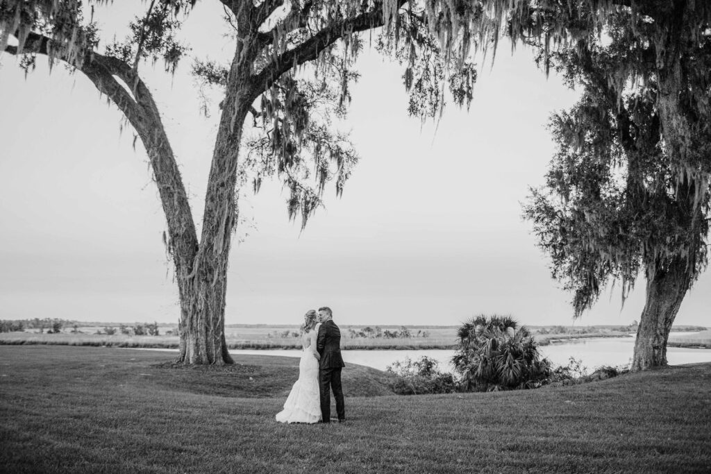 A bride and groom kiss while overlooking the Ogeechee River. 