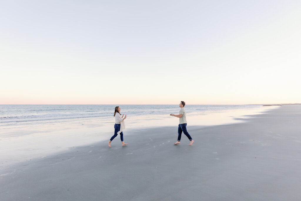 A couple runs towards one another at the beach on Sea Island. 