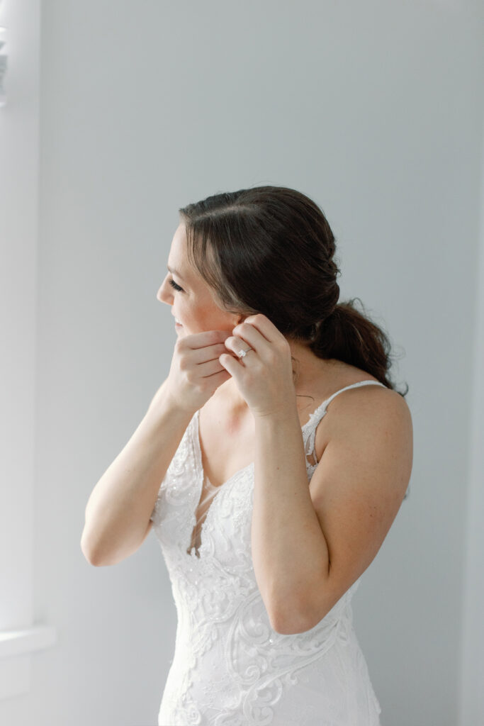 A bride putting on earrings. 