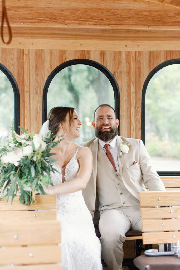 A bride and groom sit on a trolley. 