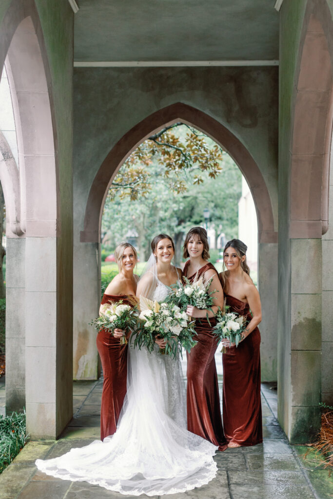 A bride and bridesmaids stand under an awning. 