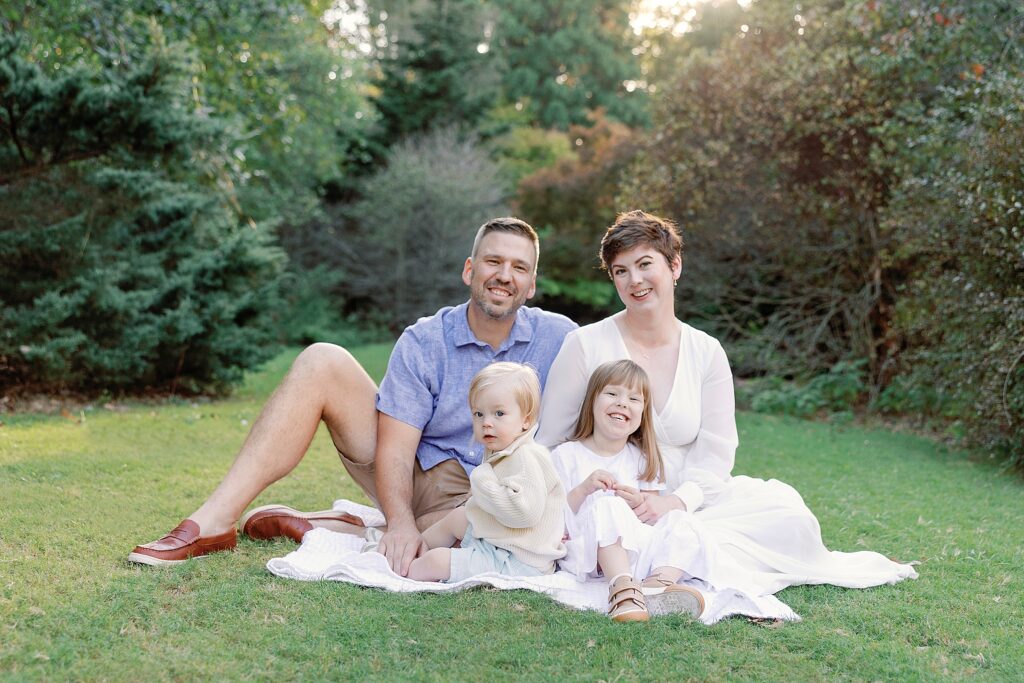 Mom dad and two kids posing on the grass in Athens Georgia during a family photoshoot